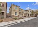 Two-story home with stucco siding, stone accents, paved driveway, and an attached two-car garage at 5233 Fiery Sky Ridge St, Las Vegas, NV 89148