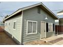 Small gray guest house with white trim, windows, and a door at 624 D Ave, Boulder City, NV 89005