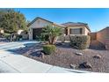 One-story home with desert landscaping and a two-car garage at 6420 Birdcall St, North Las Vegas, NV 89084