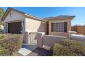 Front entrance of the house with a gate and well-maintained landscaping at 6420 Birdcall St, North Las Vegas, NV 89084