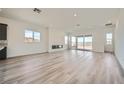 Spacious living room with wood-look floors, a modern fireplace, recessed lighting and large sliding glass doors at 66 Ibiza Lake Dr, Henderson, NV 89011