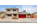 Two-story house with red garage door and small front yard at 7232 Raincloud Dr, Las Vegas, NV 89145