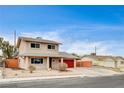 Two-story house with red garage door and spacious driveway at 7232 Raincloud Dr, Las Vegas, NV 89145