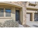 Charming front entrance featuring stone detail, desert landscaping and a dark front door at 7528 Stray Horse Ave, Las Vegas, NV 89113