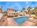 Backyard pool area of a home with palm trees and desert landscaping and partial exterior view of the home at 86 Myrtle Beach Dr, Henderson, NV 89074