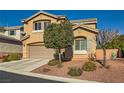 Two-story home with desert landscaping, a two-car garage, and a neutral color palette at 10260 Danskin Dr, Las Vegas, NV 89166