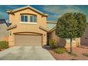 Beige two-story house with landscaping and a two-car garage at 10260 Danskin Dr, Las Vegas, NV 89166