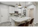 Bright kitchen features a granite countertop island with pendant lighting and stainless steel appliances at 104 Alamere Falls Dr, Las Vegas, NV 89138