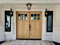 Elegant entryway with double wood doors and black framed windows at 2250 Shaw Cir, Las Vegas, NV 89117