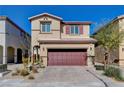 Tan two-story house showcasing desert landscaping, complemented by a red garage door and shuttered windows at 3812 Seyfert Ave, North Las Vegas, NV 89084