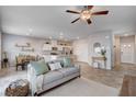 Open concept living area with tile flooring, ceiling fan, and eat-in kitchen area in neutral tones at 3812 Seyfert Ave, North Las Vegas, NV 89084