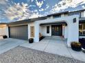 Charming home entrance with a covered porch and gray door at 3981 Ebro Way, Las Vegas, NV 89103