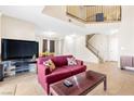 Open-concept living room with tile flooring, staircase, and lots of natural light at 4248 Tolkien Ave, Las Vegas, NV 89115