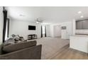 Spacious living room with grey sectional sofa, carpet, and hardwood floors at 4904 Siglo St, North Las Vegas, NV 89031