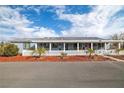 House with a covered porch, white picket fence, and palm trees at 5521 Money St, Pahrump, NV 89048