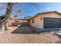 Front view of a house with a large tree and gravel landscaping at 607 Sierra Ln, Henderson, NV 89002