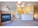 Open-concept living room featuring a cozy fireplace and adjoining kitchen at 6752 Lookout Lodge Ln # 1, North Las Vegas, NV 89084