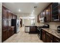 Kitchen with dark wood cabinets, granite countertops, and stainless steel appliances at 189 Carneros Ave, Henderson, NV 89002