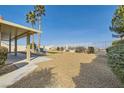 Large backyard with a covered patio, gravel, view fence, and desert landscaping at 412 Lost Trail Dr, Henderson, NV 89014