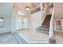 Inviting foyer with tiled floors, a staircase, and double doors leading to the interior at 412 Lost Trail Dr, Henderson, NV 89014