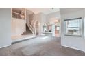 Open-concept living room featuring a high ceiling, staircase, and lots of natural light at 412 Lost Trail Dr, Henderson, NV 89014