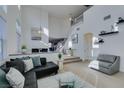 Open living area with high ceilings, L-shaped sectional, and stairs to upper level at 5859 Noble Stand St, Las Vegas, NV 89148
