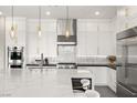 Modern white kitchen with stainless steel appliances, island with bar seating, and pendant lighting at 9145 Las Manaitas Ave # 401, Las Vegas, NV 89144