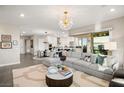 Spacious open-concept living room and kitchen featuring an elegant light fixture and plush sectional sofa at 9145 Las Manaitas Ave # 401, Las Vegas, NV 89144