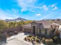 Single-story home with brown tile roof, stone accents, and landscaped front yard at 10397 Station Creek Cir, Las Vegas, NV 89178