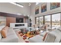 Open living space featuring a fireplace and large windows at 1341 Villa Barolo Ave, Henderson, NV 89052