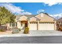 Tan house with three-car garage, landscaping, and driveway at 2138 Ponticello Dr, Henderson, NV 89052