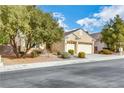 Tan house with a three-car garage and mature trees at 2138 Ponticello Dr, Henderson, NV 89052