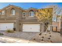 Charming two-story townhouse with a white garage door, tile roof and neat desert landscaping at 374 Yellow Finch Ln, Henderson, NV 89012