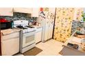 Functional kitchen with white appliances, mosaic backsplash, and tile flooring at 4130 Balboa Ave, Las Vegas, NV 89121