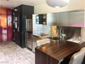 Contemporary kitchen with dark wood island and stainless steel finishes at 4381 W Flamingo Rd # 8304, Las Vegas, NV 89103