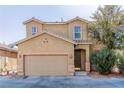 Two-story house with tan exterior, two-car garage, and landscaping at 5373 Sleeping Cat St, Las Vegas, NV 89122