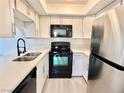 Modern kitchen with black appliances and white cabinets at 601 Cabrillo Cir # 1293, Henderson, NV 89015