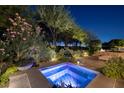 A tranquil hot tub oasis is surrounded by verdant greenery and ambient lighting for ultimate relaxation at 641 Saint Croix St, Henderson, NV 89012