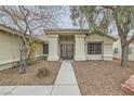 A well-maintained home exterior with decorative columns, an eye-catching front door, and desert landscaping at 6908 Bienville St, Las Vegas, NV 89131