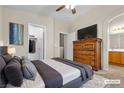A staged primary bedroom featuring a comfy bed, TV on the dresser, and a walk-in closet at 9323 Leaping Deer Pl # 102, Las Vegas, NV 89178