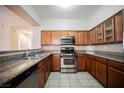 Well-lit kitchen featuring stainless steel appliances, wood cabinets, and beautiful granite countertops at 10233 King Henry Ave # 203, Las Vegas, NV 89144