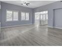 Bright, spacious living room with plank flooring, multiple windows, and a ceiling fan at 11268 Lavandou Dr, Las Vegas, NV 89141