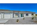 Stylish single-story home featuring a three-car garage, desert landscaping, and a covered entrance at 2280 S Pampa Ave, Pahrump, NV 89048