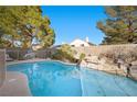 Refreshing pool featuring an attractive rock waterfall feature, set within a serene backyard at 3324 Canyon Lake Dr, Las Vegas, NV 89117