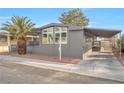 Gray single-wide manufactured home with carport and palm tree at 3580 Allegheny Dr, Las Vegas, NV 89122