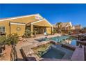 Relaxing backyard pool with a raised spa, covered patio, lush landscaping, and desert views at 5635 Exotic Rosette Ave, Las Vegas, NV 89139