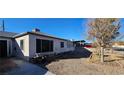 A single story home with a gravel front yard and a peek at the back yard at 612 Essex East Dr, Las Vegas, NV 89107