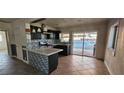 Kitchen with dark cabinets, quartz countertops and sliding door to backyard at 612 Essex East Dr, Las Vegas, NV 89107