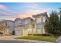 Charming two-story home with a well-manicured lawn, attached garages, and beautiful curb appeal at 99 Teton Pines Dr, Henderson, NV 89074