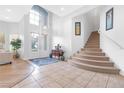 Bright foyer with tile flooring, staircase, soaring ceilings, and natural light creating an inviting entrance at 99 Teton Pines Dr, Henderson, NV 89074